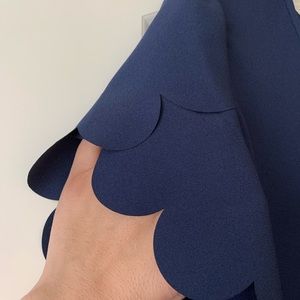 Navy blue top with scalloped cuffs edges.